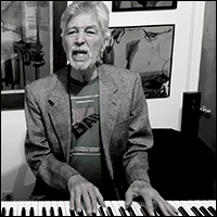 Jonathan Ochshorn playing piano and singing